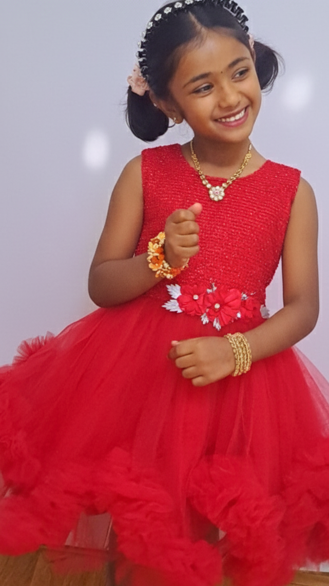 Young girl in a red dress with floral details on a light gray background