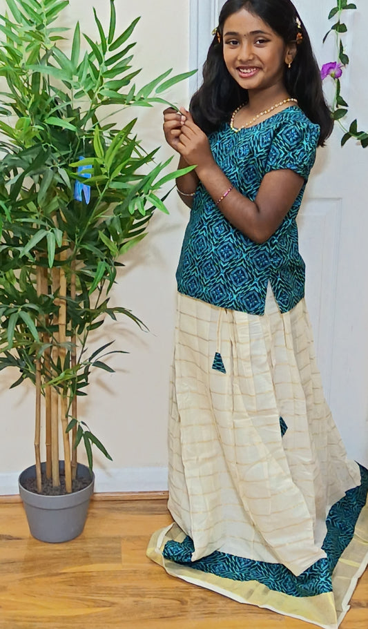 Girl dancing in teal ajrakh ethnic set with cream gold kasavu skirt and matching border
